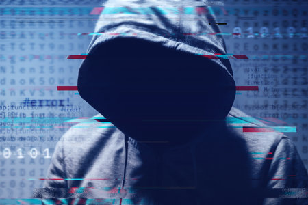 Faceless hooded hacker surrounded by digital computer code and binary digits, concept of cybercrime, data breach, and online security. Selective focus.の写真素材