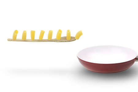 Paccheri, a typical italian pasta, march on wooden spoon into a ceramic pan.の写真素材