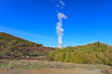 Geothermal energy. Industrial cooling tower in a green valley. Tuscany, Italy.の写真素材