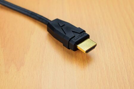 Hdmi gold connector black cable close up for hd television 1080p or blu ray 3d player on wooden...