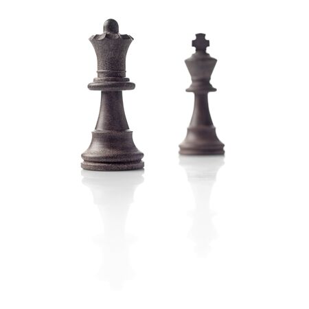 Chess  Black Queen and King out of focus and their shadows reflection on white background  Winner, power, competition or leadership men women concept の写真素材