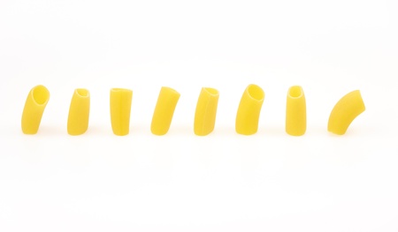 Italian pasta macaroni Paccheri and their shadow standing in a row on white background
