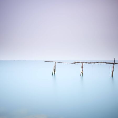 Fishing poles for clams and mussels and soft water on a quiet water landscape   の写真素材