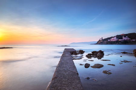 Castiglioncello travel destination, concrete pier in the bay, rocks and sea on sunset. Tuscany, Italy, Europe. Long Exposureの写真素材
