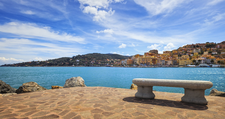 Bench on seafront in Porto Santo Stefano harbor, Monte Argentario, Tuscany, Italy.の写真素材