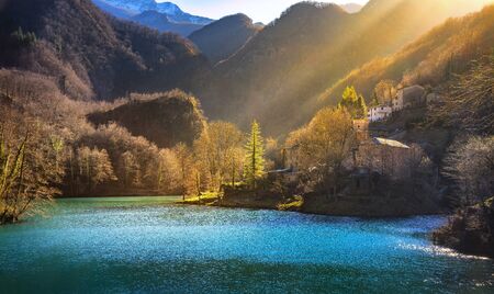 Isola Santa medieval village, church, lake and Alpi Apuane mountains. Last sunbeam of the day. Garfagnana, Tuscany, Italy Europeの写真素材