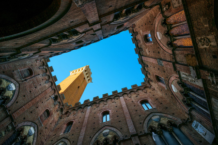 Siena landmark photo. Cortile del Podesta courtyard, Torre del Mangia tower and Palazzo Pubblico building. Bottom view. Tuscany, Italyのeditorial素材