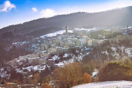 Snow in Tuscany, winter panorama at sunset. Castelnuovo Val di Cecina village. Pisa, Italy Europe.