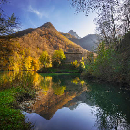 Isola Santa medieval village, lake and Alpi Apuane mountains in autumn foliage. Garfagnana, Tuscany, Italy Europe.の写真素材