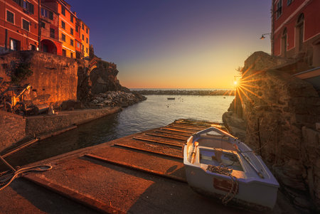 Riomaggiore village, a boat in front of the sea at sunset. Cinque Terre National Park, Liguria region, Italy, Europe.の写真素材