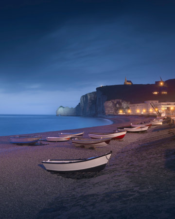 Blue hour over the boats and beach of Etretat on a foggy evening. Panoramic view. Normandy region, France, Europe.の写真素材