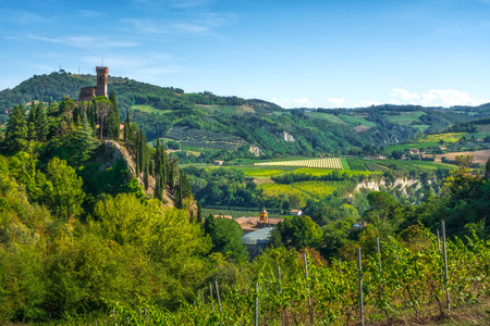 Brisighella historic clock tower on the cliff, known as the Torre dell'Orologio. Vineyards in the...