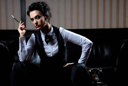 Woman on the striped background wearing business clothes, smoking.の写真素材