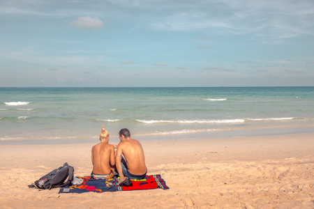 Man and woman have a picnic on a tropical beach, sitting on a blanket, Haad Rin, Koh Pangan, May 05, Thailandのeditorial素材