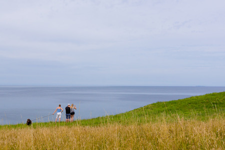 Family standing in the grass high above  the sea, Hundested, Denmark, July 10, 2017のeditorial素材