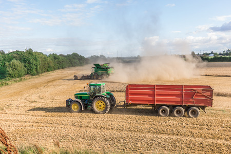 Tractor and combine engaged in harvesting grain, Borkop, Denmark , August 27, 2017のeditorial素材