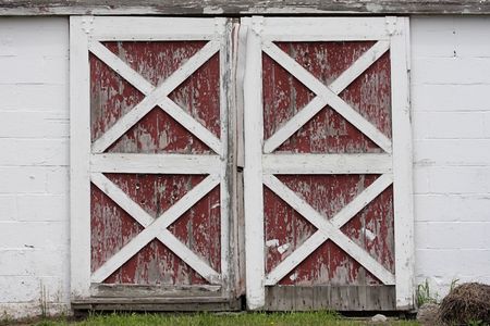 Rustic old red and white barn doors with peeling paintの写真素材