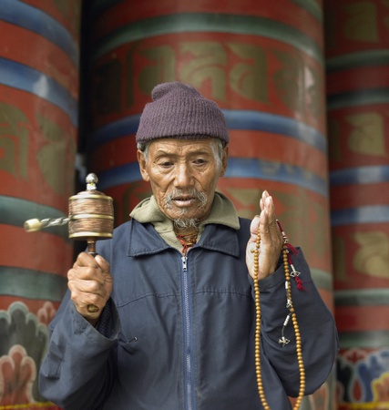 A Bhutanese man with prayer wheel in Paro Dzong in the Kingdom of Bhutan.のeditorial素材
