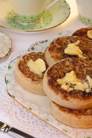 Tea and toasted crumpets with lashings of melting butter for Breakfast  A crumpet is a savoury griddle cake made from flour and yeast の写真素材