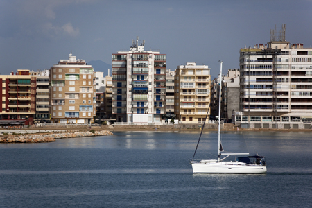 A yacht sailing by the waterfront of Torrevieja on the Costa Blanca in southern Spain の写真素材