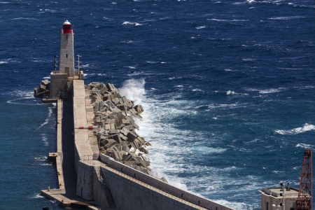 A breakwater protects the inner harbor from the rough sea at the entrance to the Vieux Port in Marseille in the South of France の写真素材
