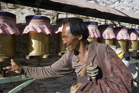 A Buddhist pilgrim turning prayer wheels at the Yambulagang Monastery in Tibet.のeditorial素材