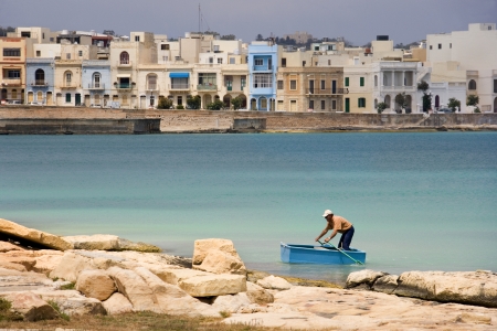 Local man in a small rowing boat near Birzebbuga on the Mediterranean island of Maltaのeditorial素材