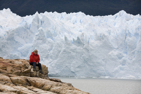 Hiker resting near Perito Moreno Glacier. The Perito Moreno Glacier is located in the Los Glaciares National Park in the south west of Santa Cruz province in Patagonia, Argentina (Model Released) のeditorial素材
