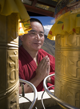 Tibetan monk and preyer wheels at Ganden Monastery high in the Himalayasのeditorial素材