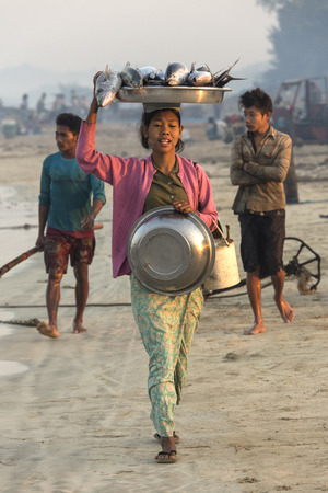 Burmese woman with her catch of fish, near the fishing village on Ngapali Beach in Myanmar - Burma  のeditorial素材