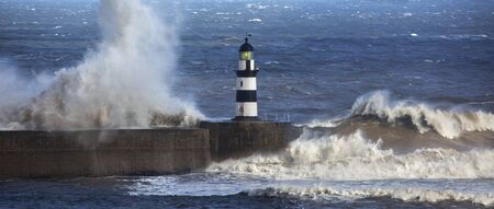Waves crashing over Seaham Lighthouse on the northeast coast of England の写真素材