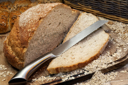 A freshly baked loaf of bread on a breadboard in farmhouse kitchen