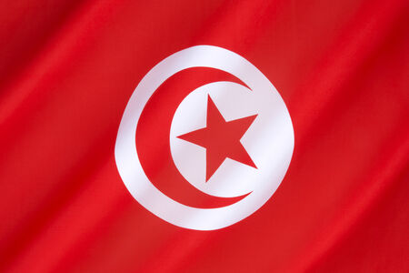 Flag of Tunisia - has its origins in the naval ensign of the Kingdom of Tunis. The star and crescent recalls the Ottoman flag and is therefore an indication of Tunisian history as a part of the Ottoman Empire. The current official design dates from 1999.の写真素材