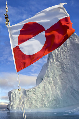 Flag of Greenland - Adopted 21st June 1985. The flag of Greenland is the only national flag of a Nordic country or territory without a Nordic Cross. Photographed in Scoresbysund, eastern Greenland.の写真素材