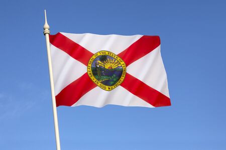 Flag of Florida - United States of America. The flag has a red saltire (St. Andrews Cross) on a white background, with the state seal in the center. The current design has been in use since 21st May 1985.の写真素材