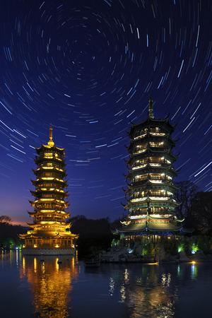 Astronomy - Star Trails over the twin pagodas of Fir Lake in the city of Guilin in the Guangxi Zhuang region of China.のeditorial素材