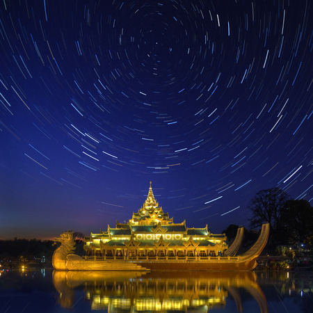 Star trails above the Karaweik, a replica of a Burmese Royal Barge on Kandawgyi Lake in Yangon in Myanmar. Although a national landmark it now houses a restaurant.のeditorial素材