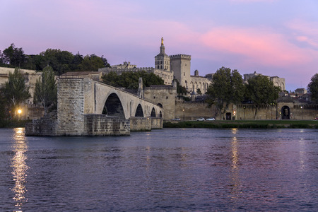 Dusk over the Pont d'Avignon (Pont Saint-Benezet) and the city of Avignon in the department of Vaucluse on the left bank of the Rhone River. it was the residence of the popes during their exile from Rome. Between 1309 and 1377, seven successive popes resiの写真素材