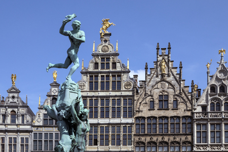 Antwerp - Belgium. Statue of Silvius Brabo throwing the giants hand towards the 16th century Guildhouses of the Grote Markt.のeditorial素材