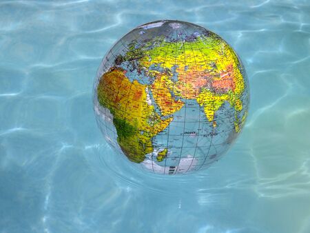 A world globe showing Europe, Africa and Asia floating on water.