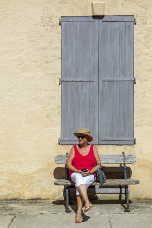 Tourist sitting outside a building near Vitrac in the Dordogne in the Nouvelle-Aquitaine region of France.のeditorial素材
