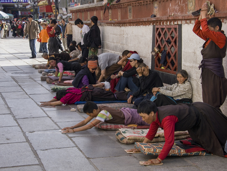 Tibetan Buddhist pilgrims outside the Jokhang Temple on Barkhor Square in Lhasa, Tibet. Tibetans, consider this temple the most sacred and important temple in Tibet.のeditorial素材