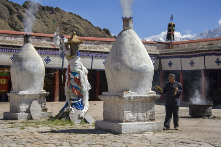 A Buddhist pilgrim burning incense at Chokpori Hill Buddhist shrine in Lhasa in the Tibet Autonomous Region of China.のeditorial素材