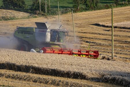 A combine harvester cutting a field of wheat on a farm in North Yorkshire in the United Kingdom.