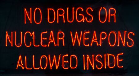Red Neon Sign in the window of a bar in Dublin, Ireland - No Drugs or Nuclear Weapons Allowed Inside.の写真素材