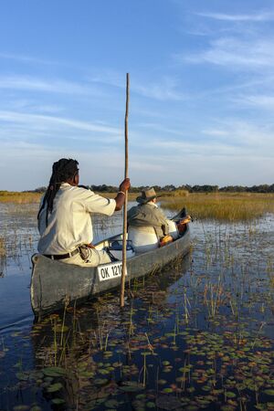 Okavango Delta. Botswana. 05.27.09. Safari guide with tourist in a Makoro exploring the Okavango Delta in northern Botswana, Africa.のeditorial素材