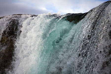 Water flowing over a waterfall at Pingvellar (Thingvellir) in Iceland.の写真素材