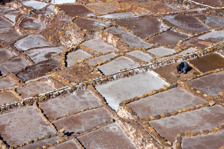 Local woman working on the Maras Salt Pans on a mountainside above Urubamba in Peru, South America.の写真素材