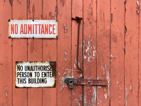 Old wooden door with warning signs.の写真素材
