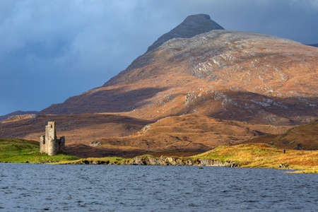 Ben Quineg and Ardvreck Castle - a ruined castle dating from the 16th century which stands on a rocky promontory in Loch Assynt in Sutherland, northwest Scotland. The castle was built in about 1590 by the MacLeods of Assynt.の写真素材
